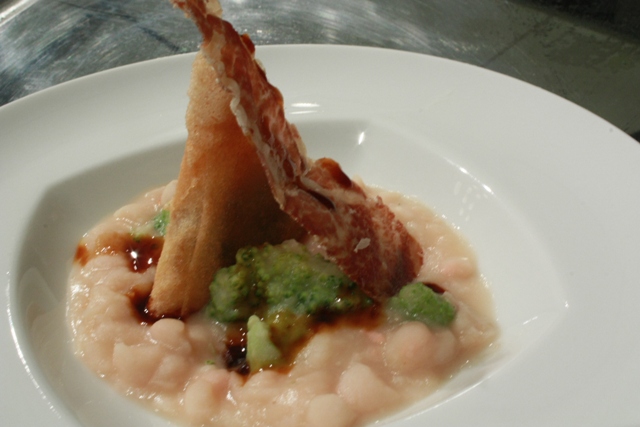 si continua con gli assaggi: Torre Coccaro con questa zuppa di fagioli con samosa di cozze e chips di capocollo di Martina